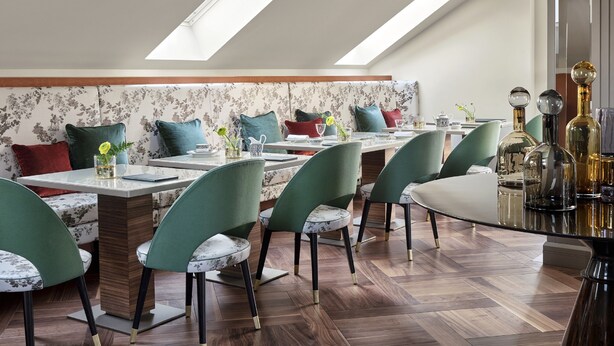 A modern dining area with a high ceiling, skylights, and a patterned wall. - Vista Verona (Verona)