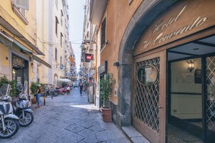 Une rue étroite, avec un hôtel appelé « Hotel Al Convento » situé sur le côté droit.