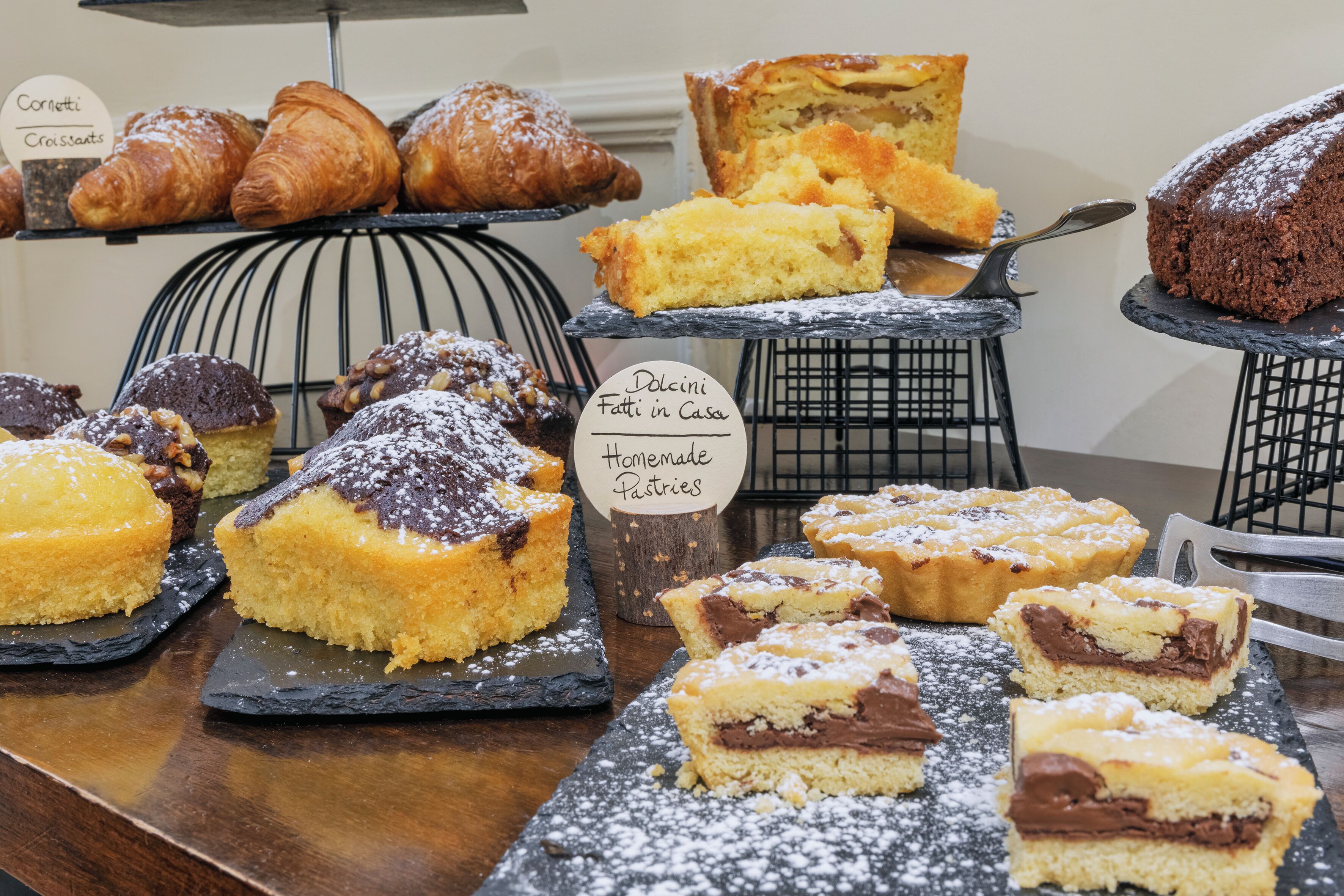 A variety of pastries and cakes displayed on a counter.