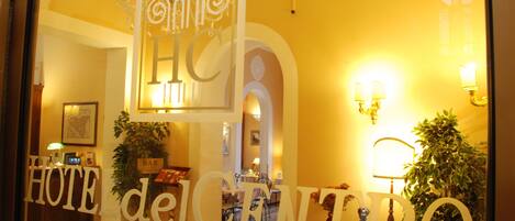 A hotel lobby with a reception desk, a bar area, and a dining space.