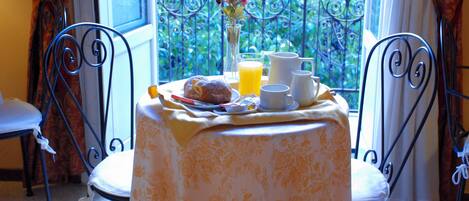 A breakfast setup with a table, chairs, and a window view.