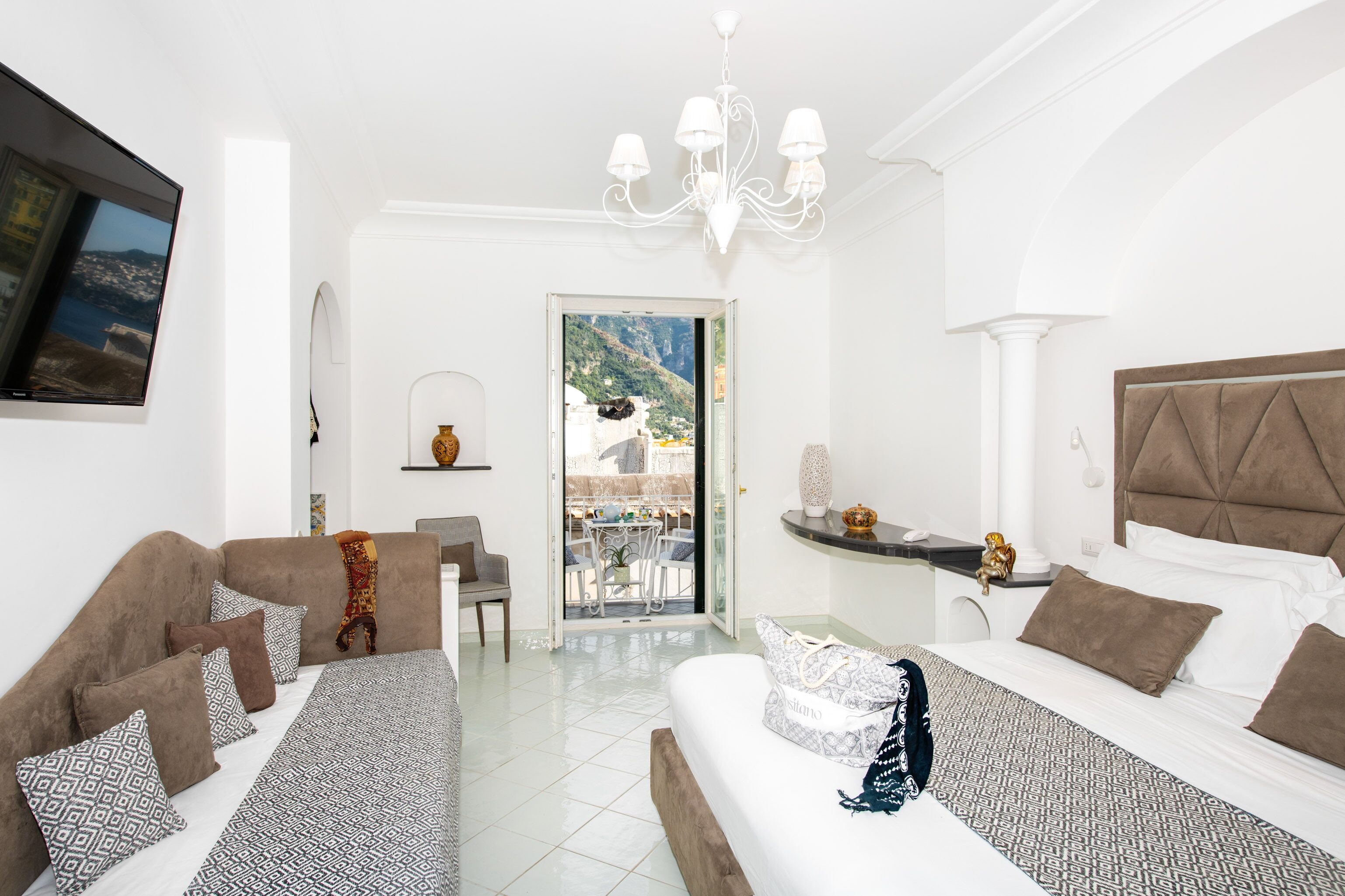 Habitación de hotel con cama, sofá, escritorio y vistas al exterior.