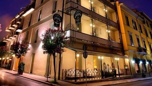 A multi-story building with balconies, a ground-level entrance, and signage indicating a restaurant. - Adua & Regina di Saba (Montecatini Terme)