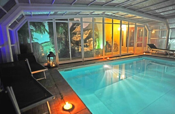 Alberca techada, alberca al aire libre y camastros