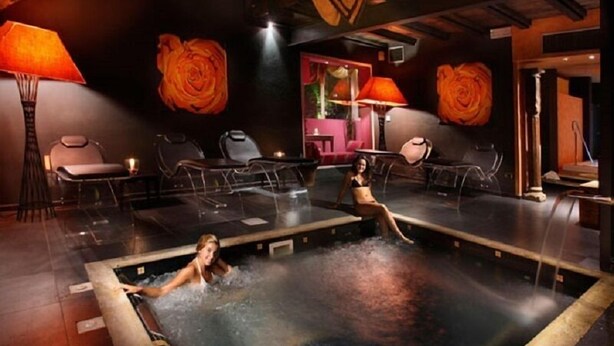 A spa area with a hot tub, seating, and decorative rose paintings. - Adua & Regina di Saba (Montecatini Terme)