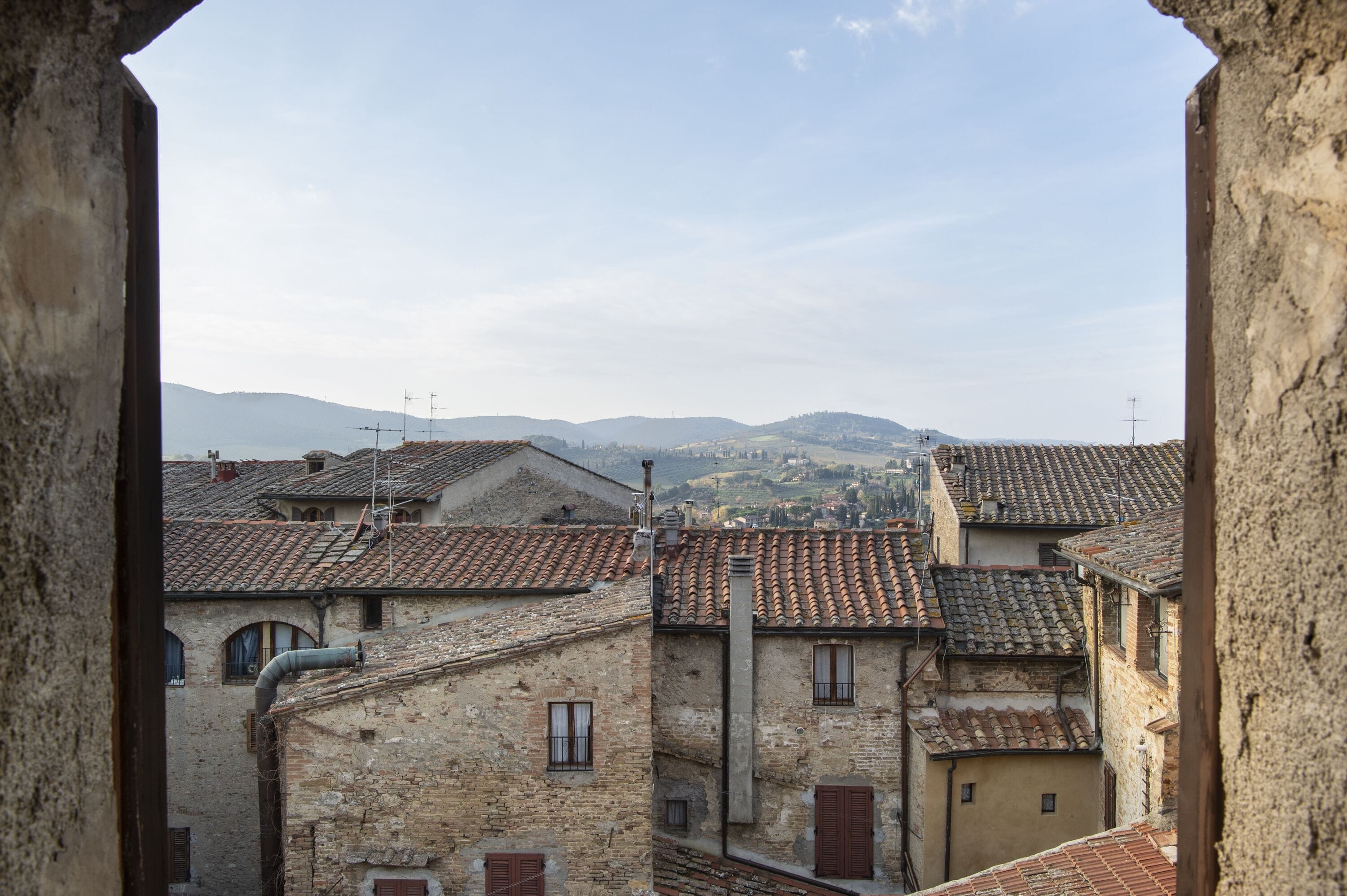 A view of a historic town with stone buildings and terracotta roofs.