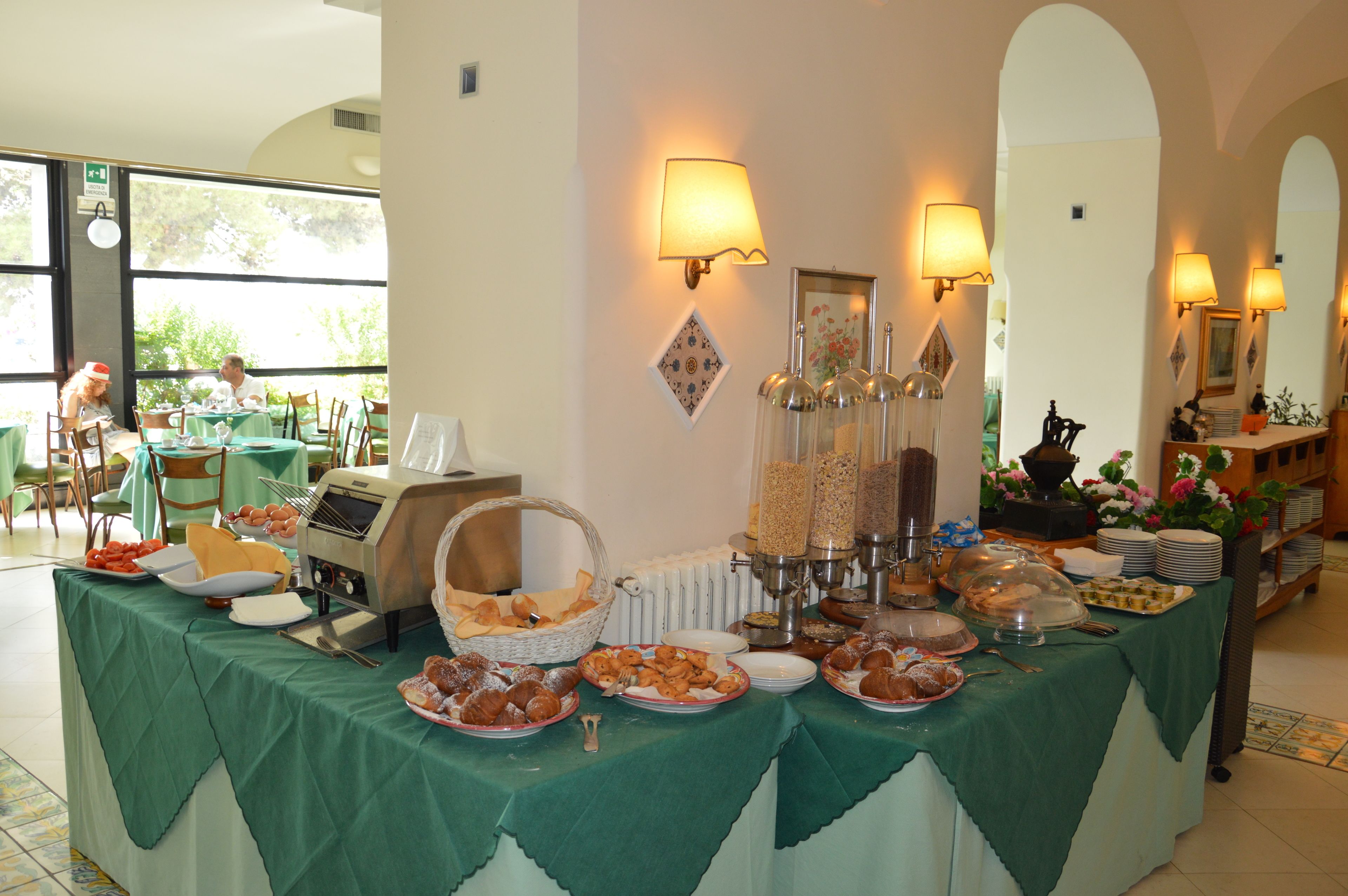 Ein reichhaltiges Buffet mit verschiedenen Speisen, einer Speisenstation und einem Essbereich mit Tischen und Stühlen.