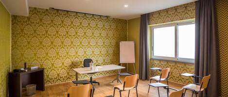 A conference room with a whiteboard, a table, and several chairs.