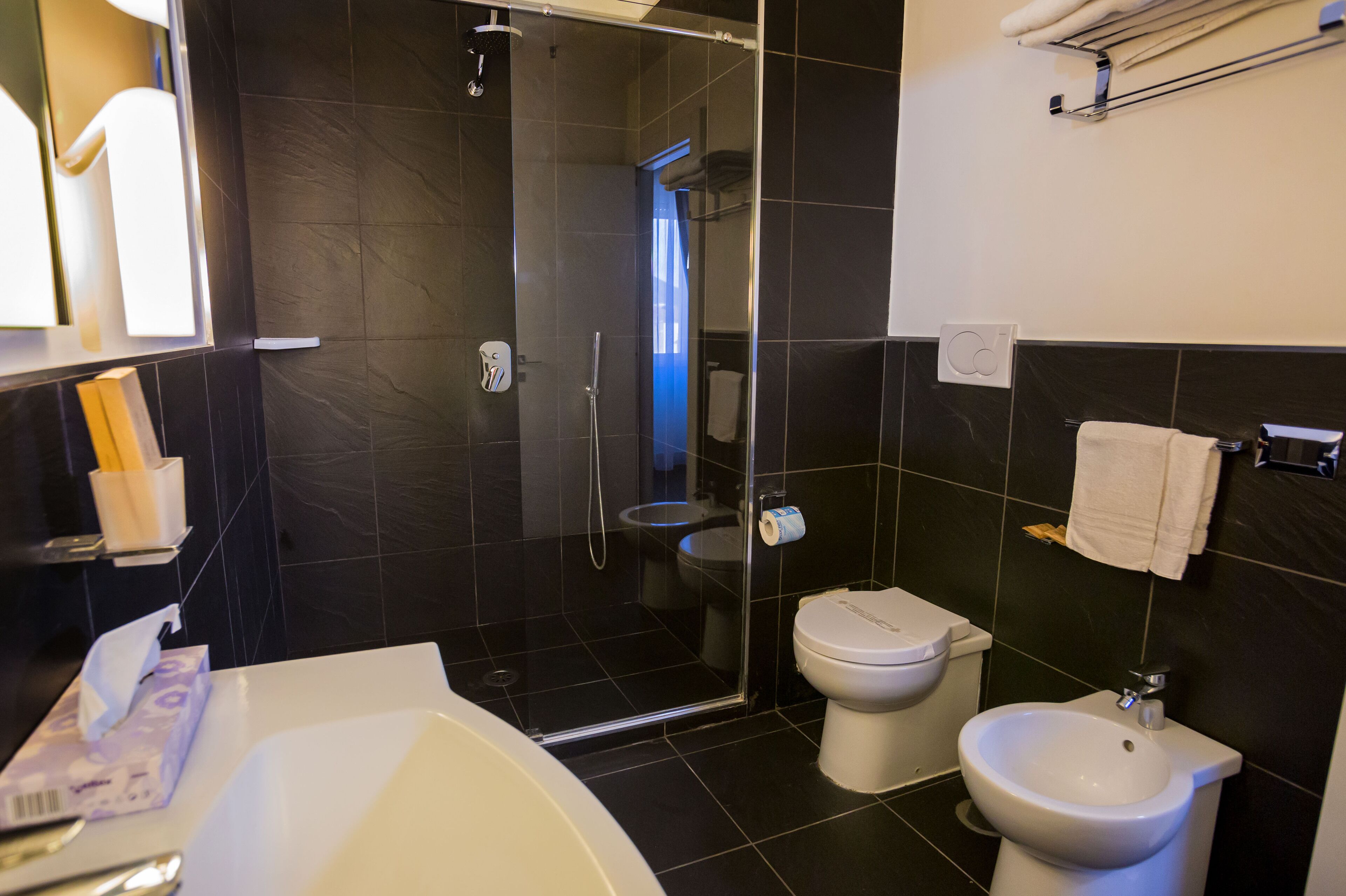 Un baño moderno con ducha envuelta en vidrio, inodoro, bidé y bañera.
