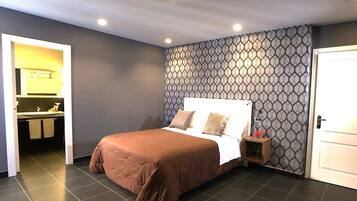 Une chambre à coucher avec un lit, une table de chevet, un miroir et une porte.
