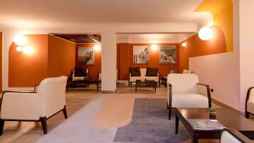 Eine moderne Hotelhalle mit weißen Ledersofas, einem Couchtisch und einem Teppich.
