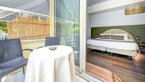 A bedroom with a large bed, a small table, and a chair. - Hotel City (Desenzano del Garda)
