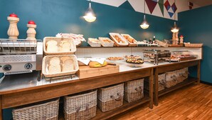 A buffet area with various food items, baskets, and a bread display. - Hotel City (Desenzano del Garda)