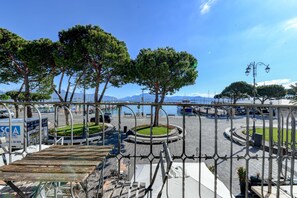 A waterfront promenade with a circular park, benches, and a metal railing. - Hotel Tripoli (Desenzano del Garda)