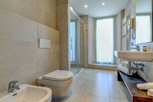 Un baño moderno con bidé, inodoro y lavabo.