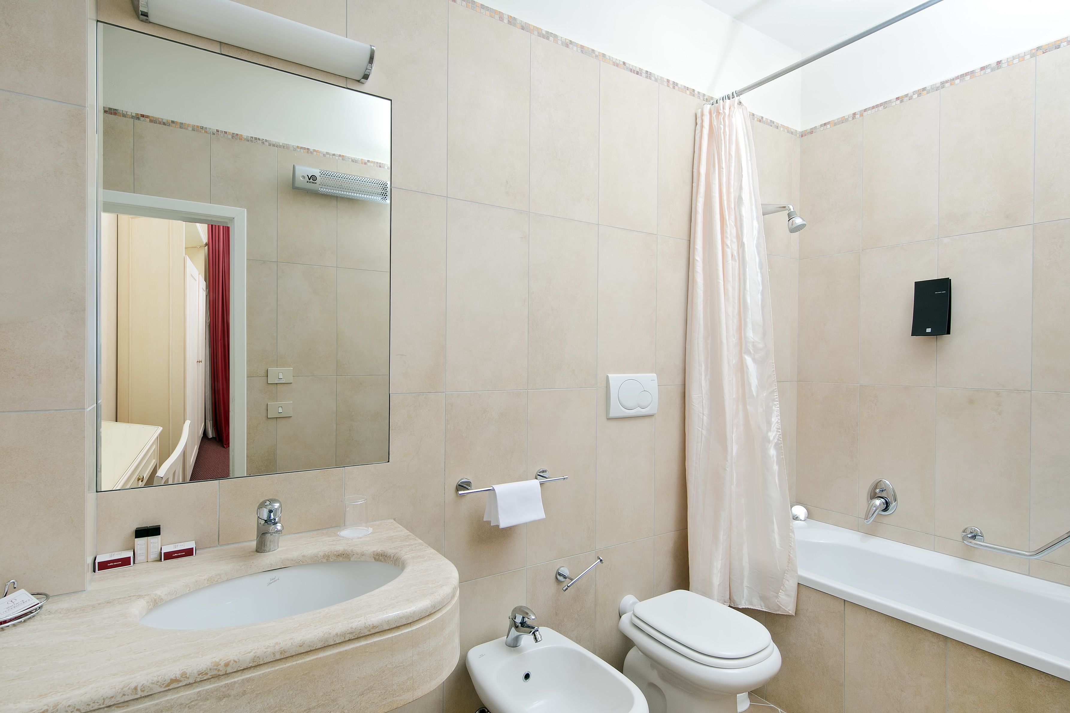 Un bagno con lavandino, bidet, WC e vasca da bagno.