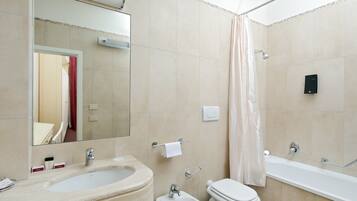 Un baño con lavamanos, bidé, inodoro y bañera.