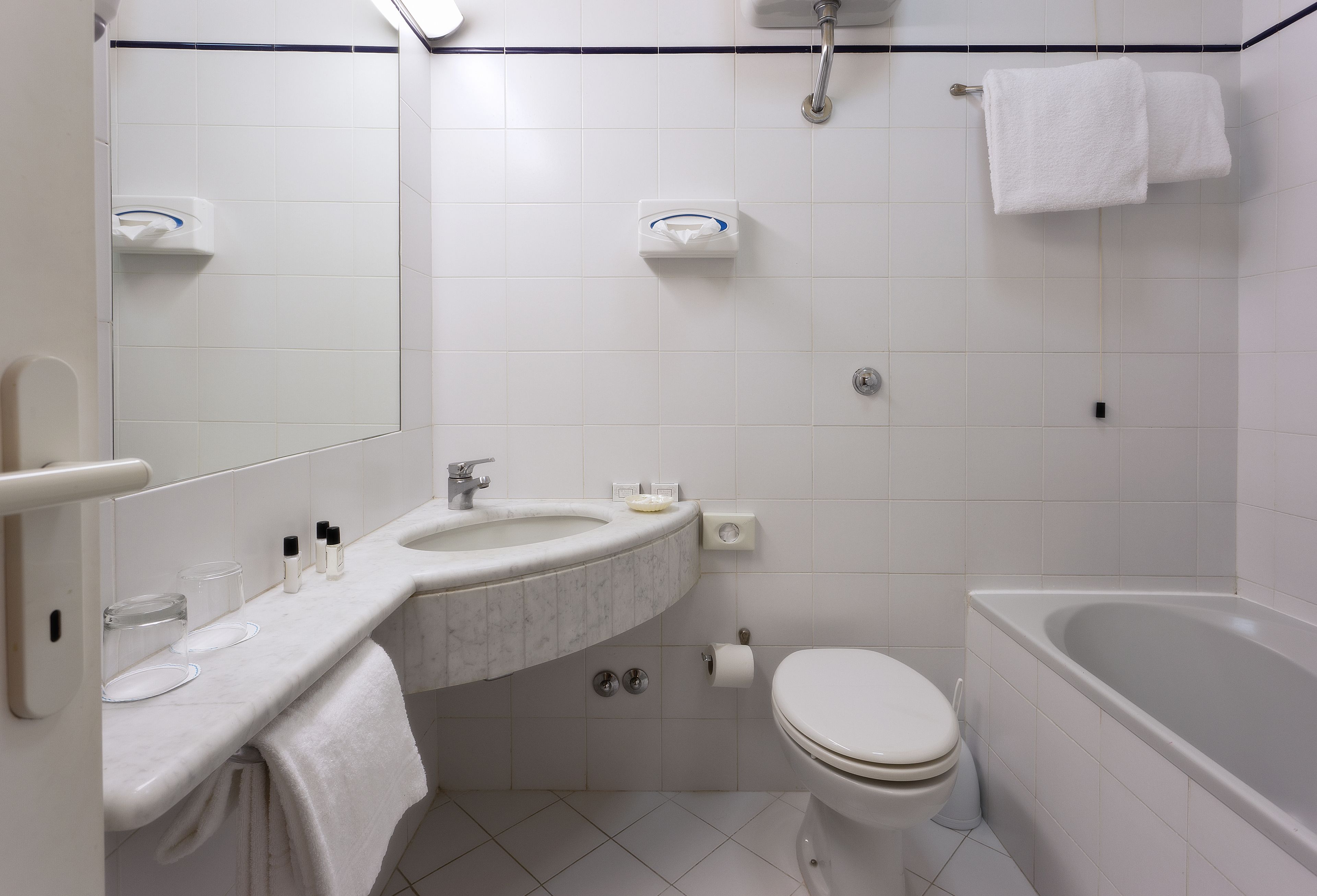 Une salle de bain moderne équipée d’un lavabo, de toilettes et d’une baignoire.