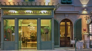The exterior of Hotel Ercolini & Savi, featuring a classic facade with large glass windows, a chandelier visible through the entrance, and a sign indicating the presence of a restaurant nearby. - Ercolini E Savi (Montecatini Terme)