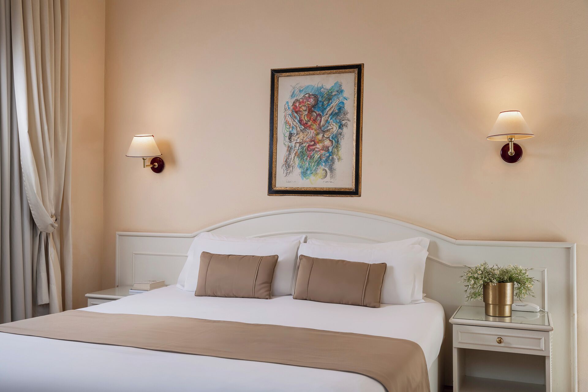 A hotel room with a bed, two bedside tables, a nightstand, a framed abstract painting, and a lamp.