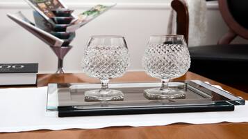 Two crystal glasses on a tray with a magazine and a book in the background.