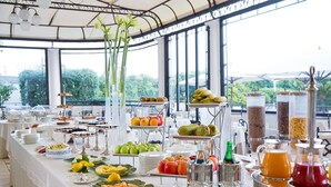 A buffet table with various food items and beverages, set in a room with large windows and a view of greenery outside. - La Medusa Dimora di Charme (Castellammare di Stabia)