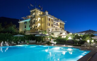 Un hotel grande de varios pisos con una piscina al frente.