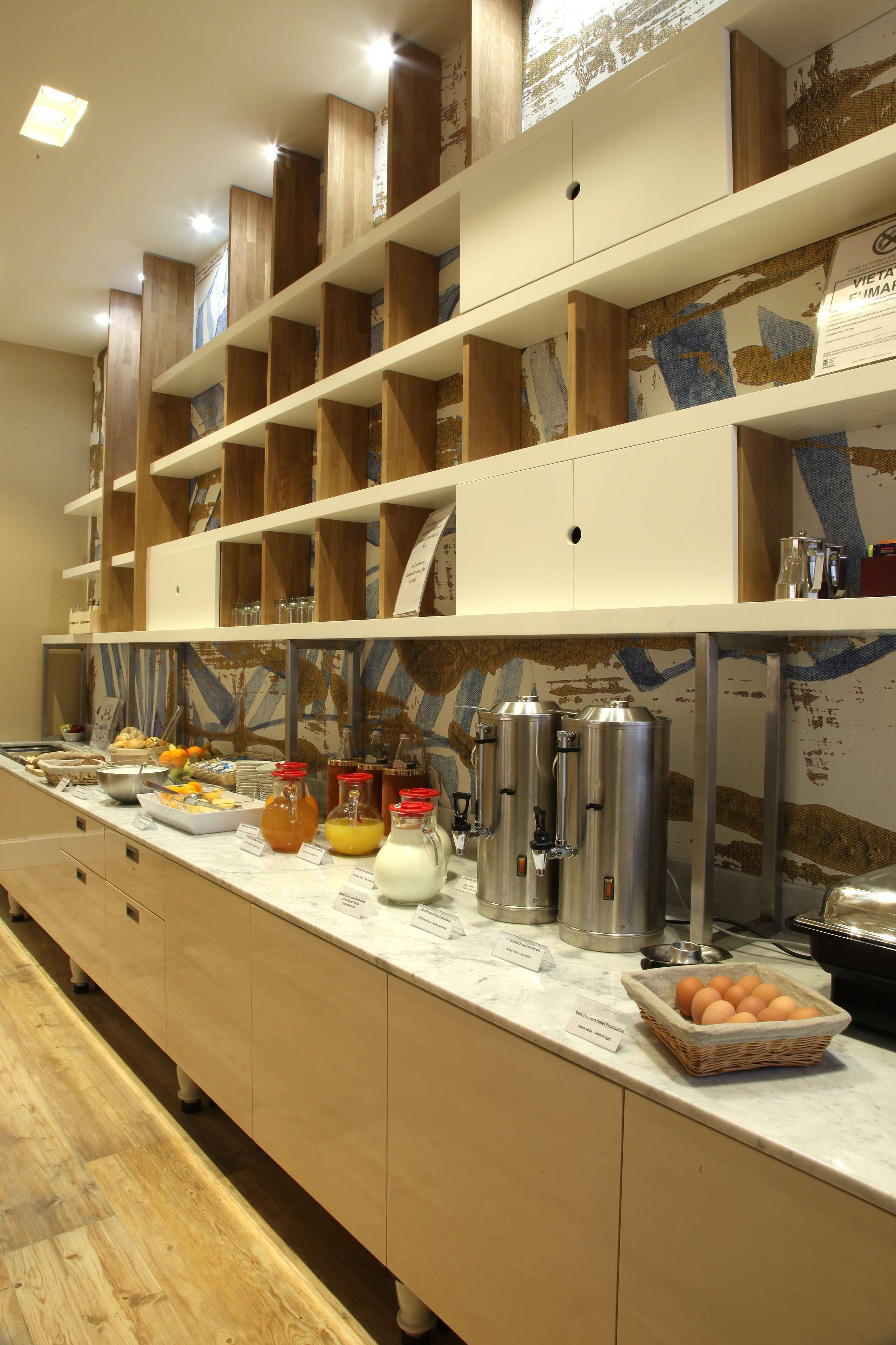 A buffet setup with various food items and beverages, including a basket of eggs, a bowl of fruit, and several bottles of juice.