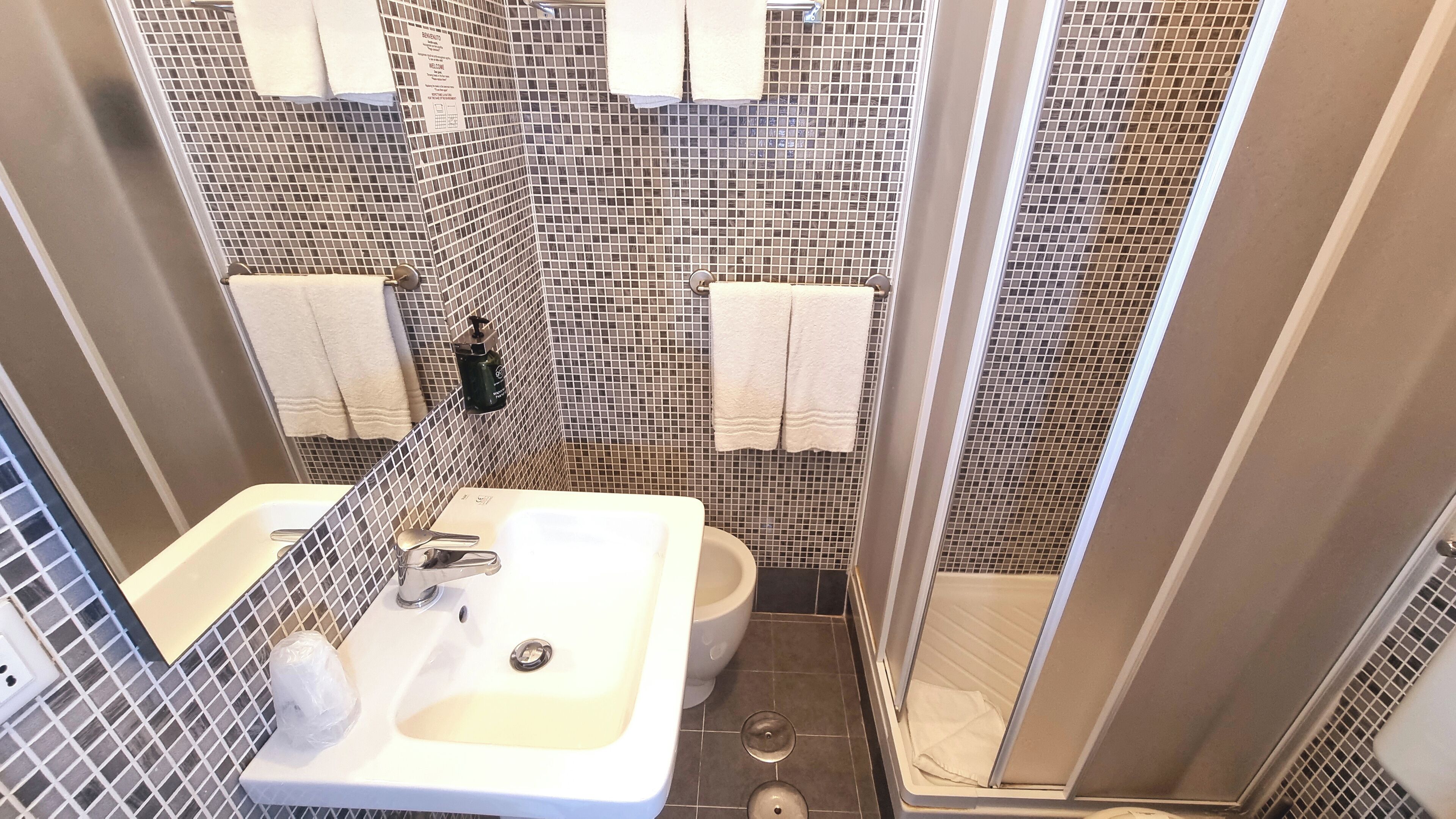 A bathroom with a white sink, a toilet, and a shower area.