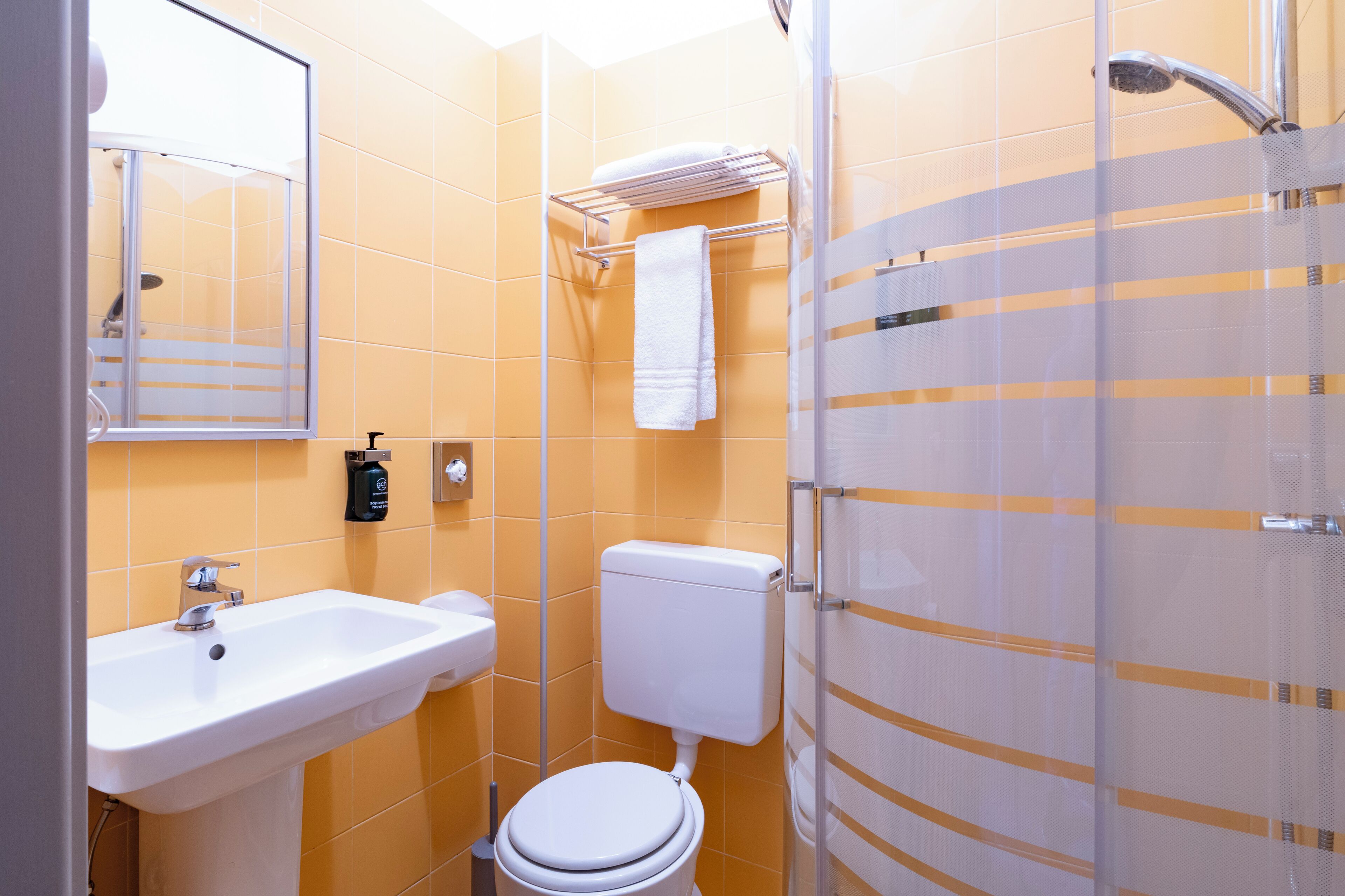 A bathroom with a white sink, toilet, and shower.