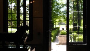 A view through a window with a view of a garden and a building in the distance. - Villa Alberti Hotel (Mira)