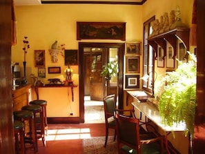 A dining area with wooden furniture, a table, chairs, and a potted plant.