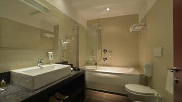 A modern bathroom with a large sink, a bathtub, and a toilet.
