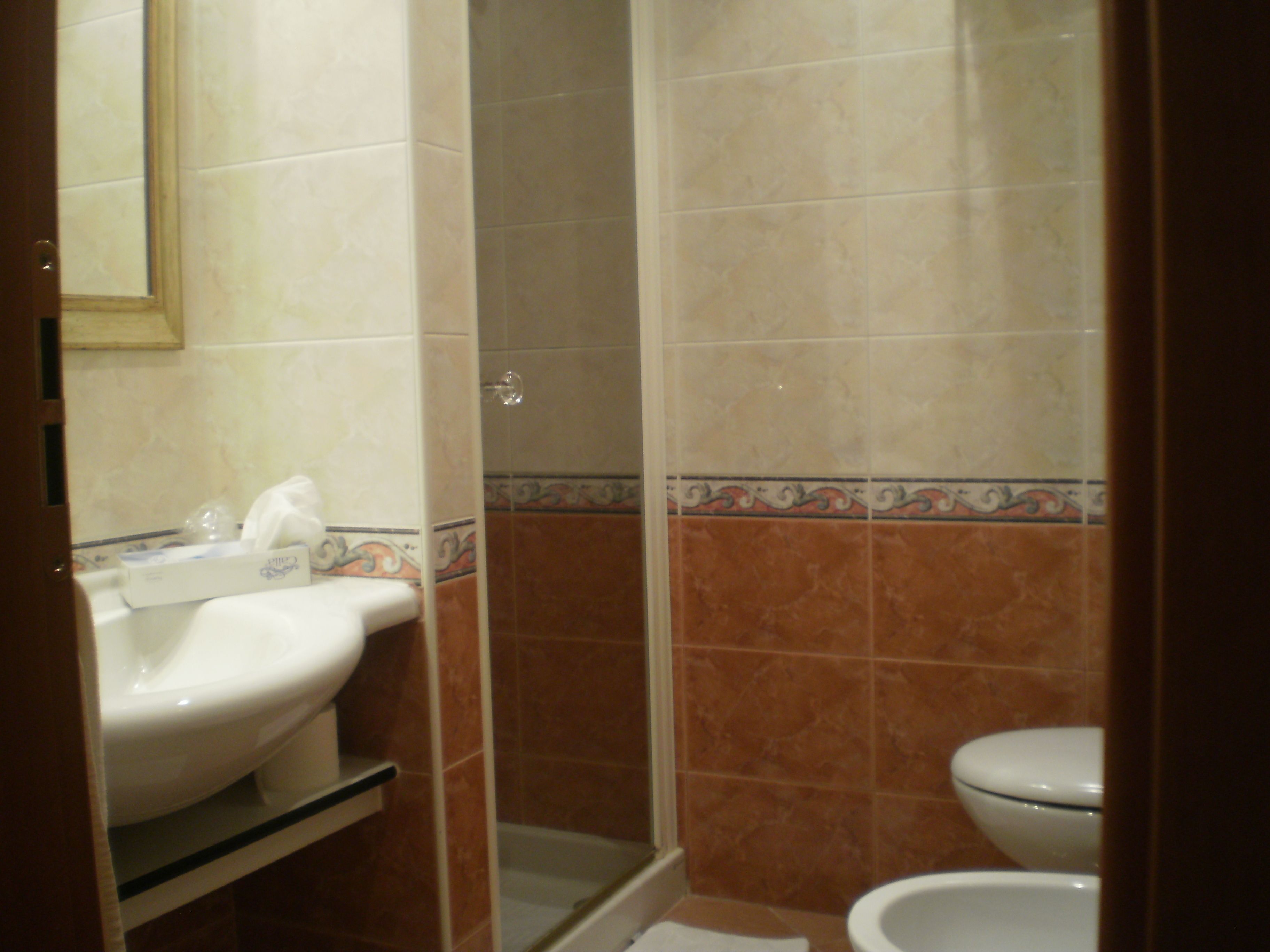 A bathroom with a sink, toilet, and shower.