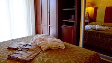 A hotel room with a bed, a bedside table, a lamp, and a wardrobe.