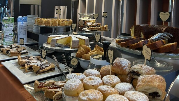 Un buffet con varie paste, torte e dolci.