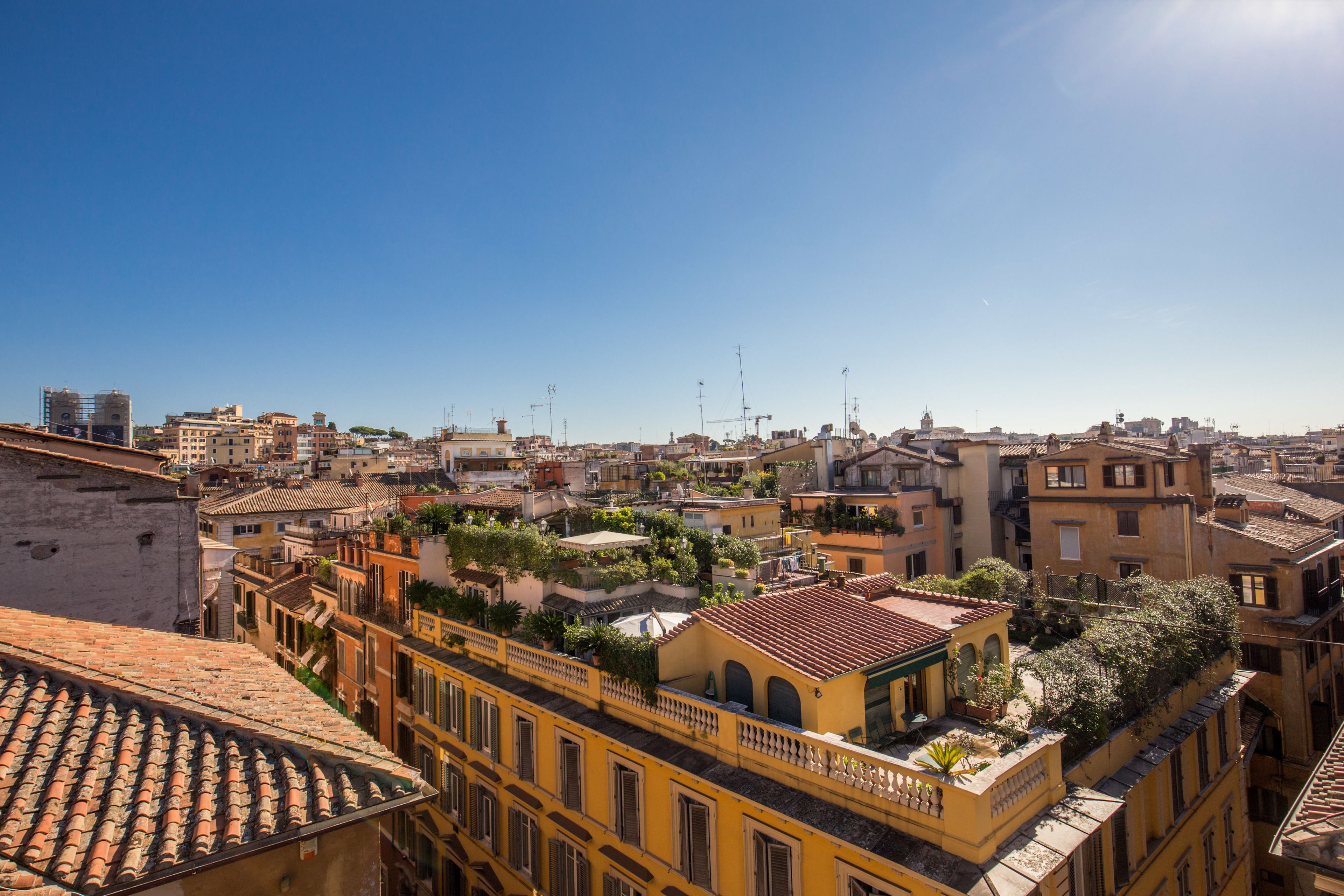 Uma área urbana densamente povoada, com diversos estilos arquitetônicos e um céu azul límpido.
