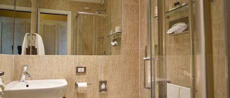 A modern bathroom with a sink, toilet, and glass shower enclosure.