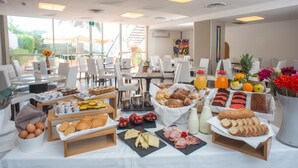 A breakfast buffet with various food items and a view of the outdoors.