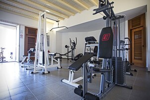 Una palestra con diverse attrezzature per esercizi, tra cui panche e macchinari per pesi.
