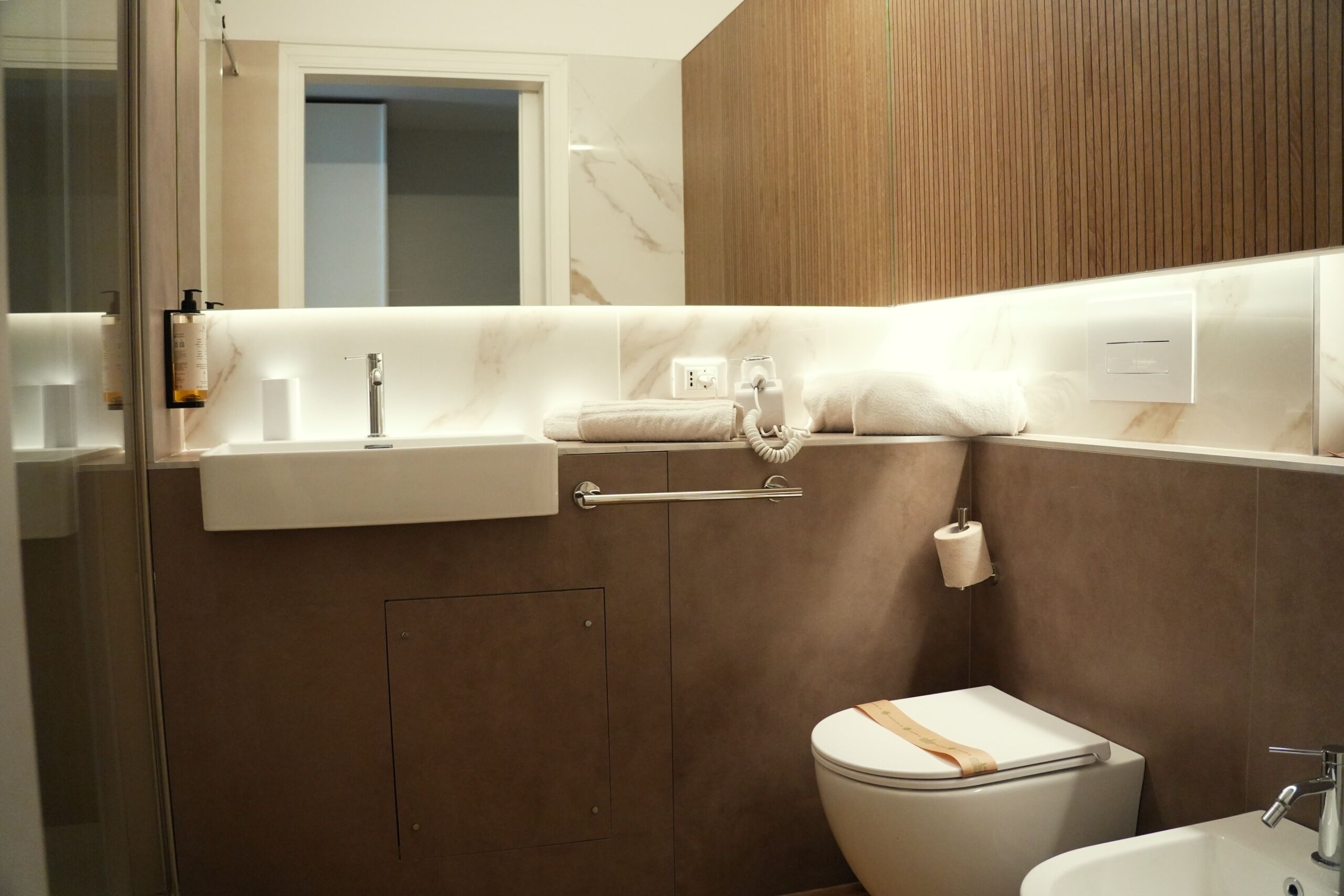 A modern bathroom with a toilet, sink, and shower area.