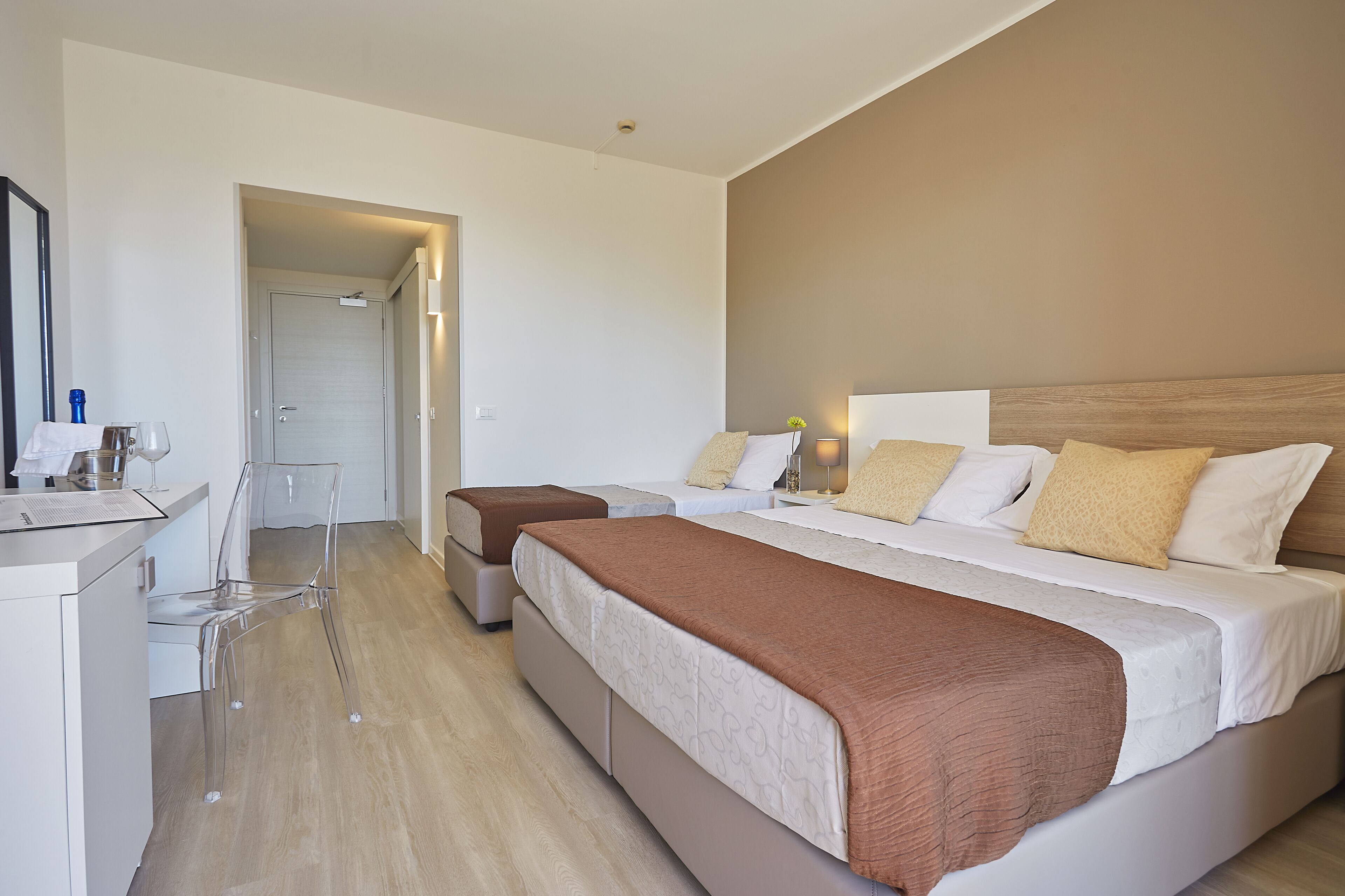 Una camera d'albergo moderna con un letto grande, una scrivania e una sedia.