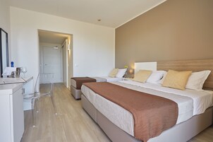 Una camera d'albergo moderna con un letto grande, una scrivania e una sedia.