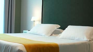 Une chambre d’hôtel avec un lit, une table de chevet, une lampe et une fenêtre avec des rideaux.