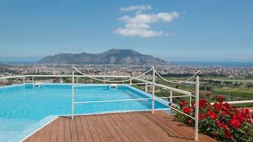 Una piscina al aire libre de temporada, sombrillas