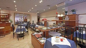 Restaurante com várias mesas e cadeiras, área de bar e prateleiras com diversos itens.