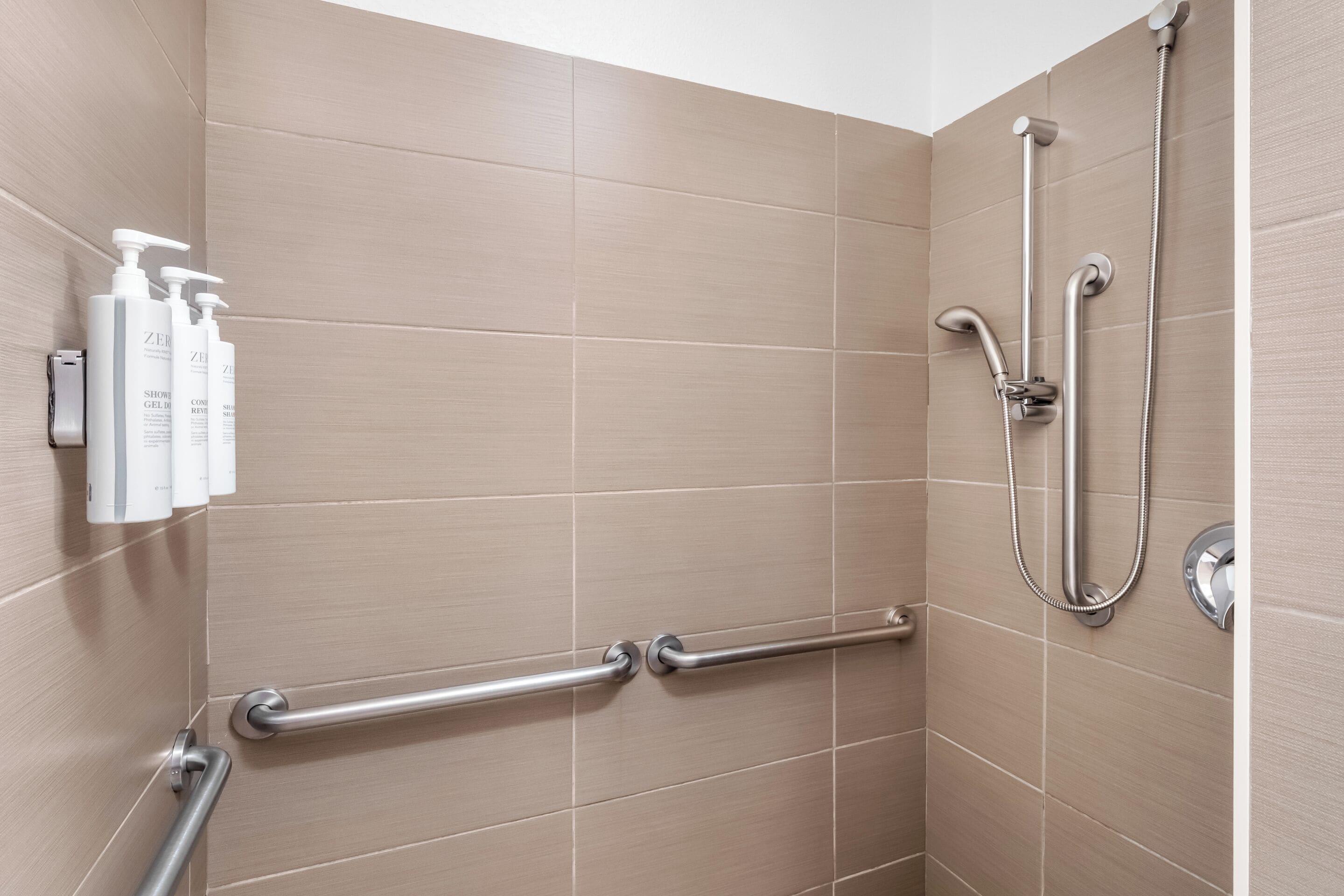 Une douche équipée d’un pommeau de douche à main, d’un autre pommeau de douche à main et d’un troisième pommeau de douche à main.