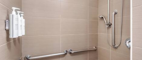Une douche équipée d’un pommeau de douche à main, d’un autre pommeau de douche à main et d’un troisième pommeau de douche à main.