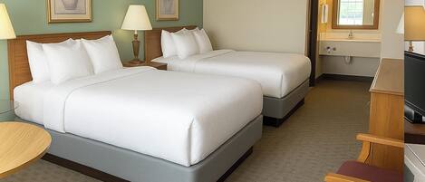 A hotel room with two beds, a desk, a chair, and a TV.