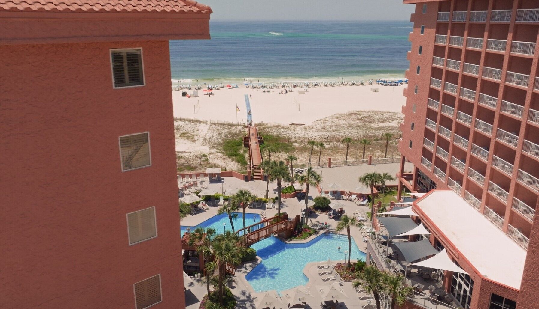 A resort with a pool, beach access, and a view of the ocean.